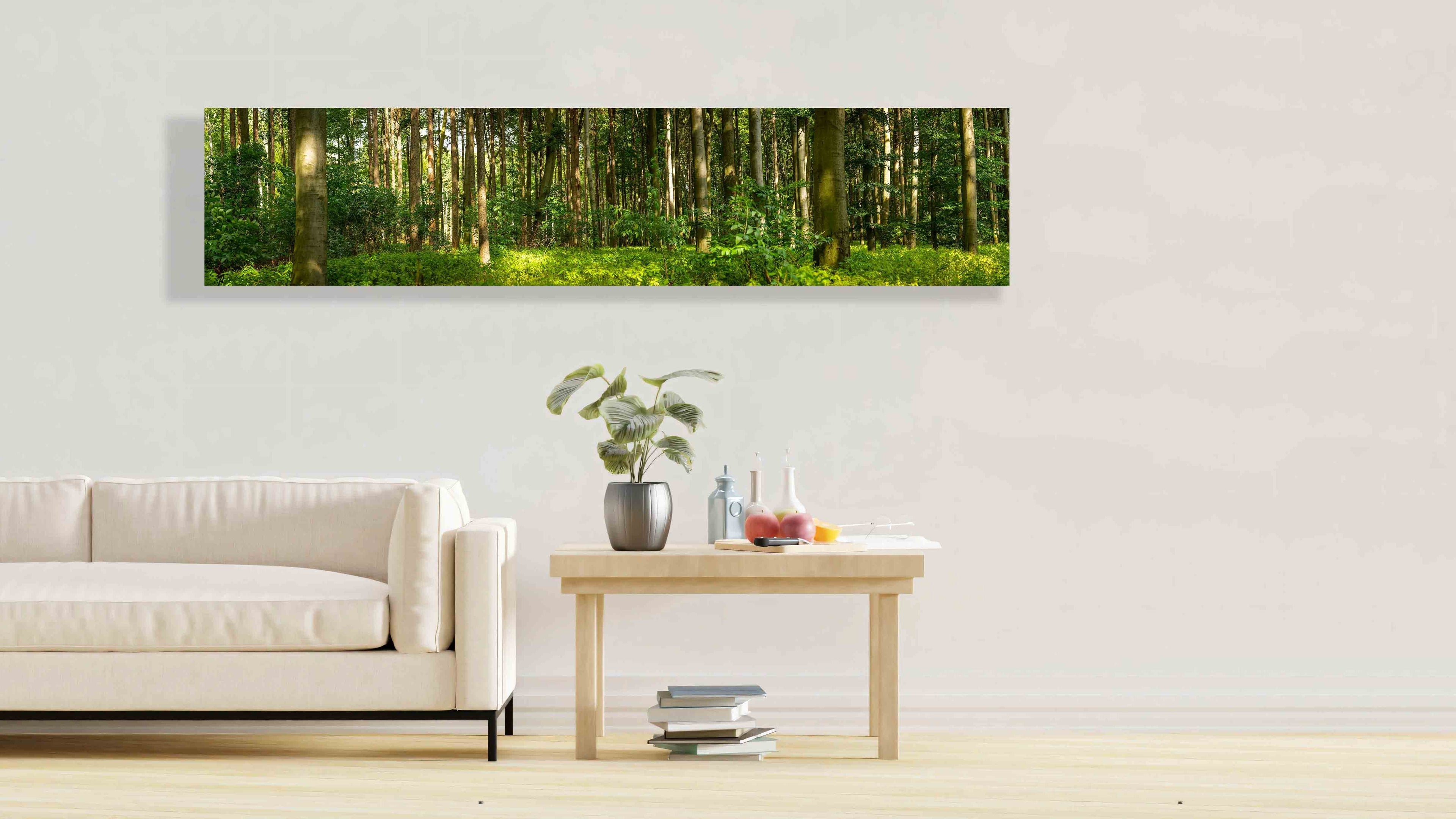 Fine art print from CamachoPhotography of a green forest in a panorama format hanging on a white wall of a home, decorating beautifully the living room that has a white couch and weed side table and wooden floor to inspire and make people feel good. This is one of the products offered in CamachoPhotography Décor Shop po