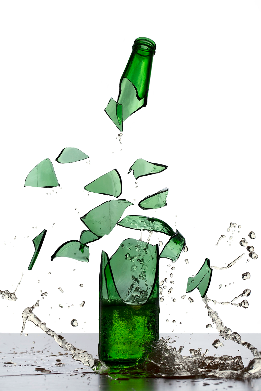 The explosive energy of a green beer glass bottle shattering into pieces, each fragment suspended in mid-air with stunning clarity. Actual format of the artwork.