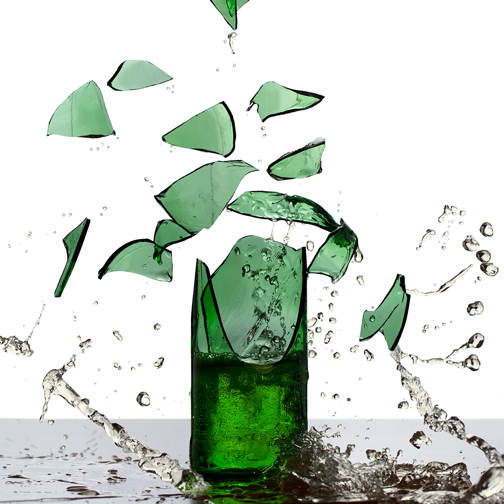 Thumbnail of the explosive energy of a green beer glass bottle shattering into pieces, each fragment suspended in mid-air with stunning clarity.