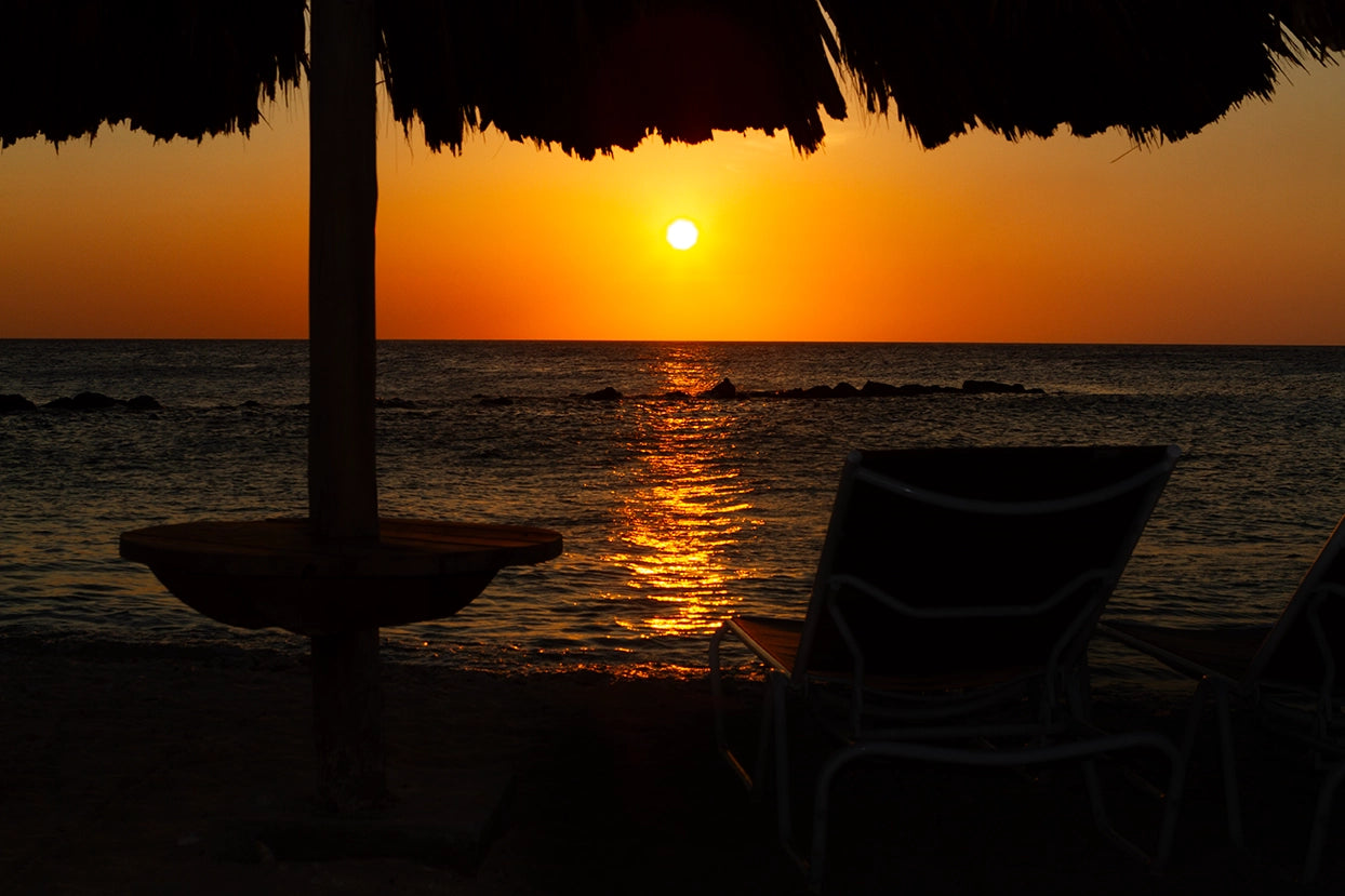 Breathtaking image of a golden sunset in Curacao casting its warm glow over the peaceful Caribbean Sea. Actual format of the artwork.