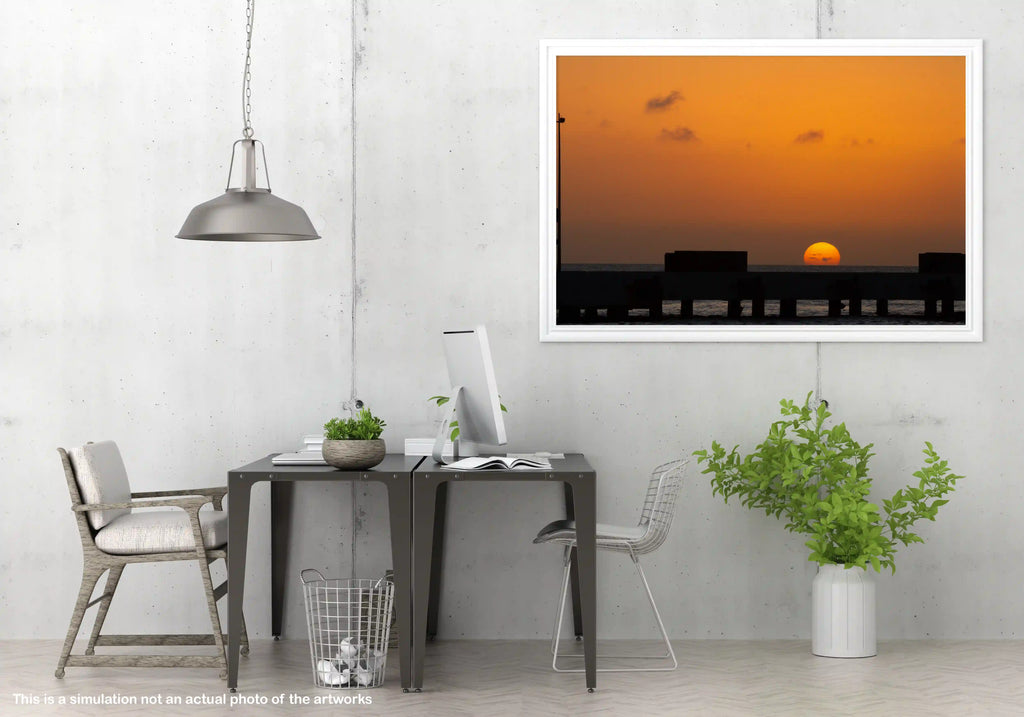 Modern office space with a framed artwork of a city skyline at sunset.