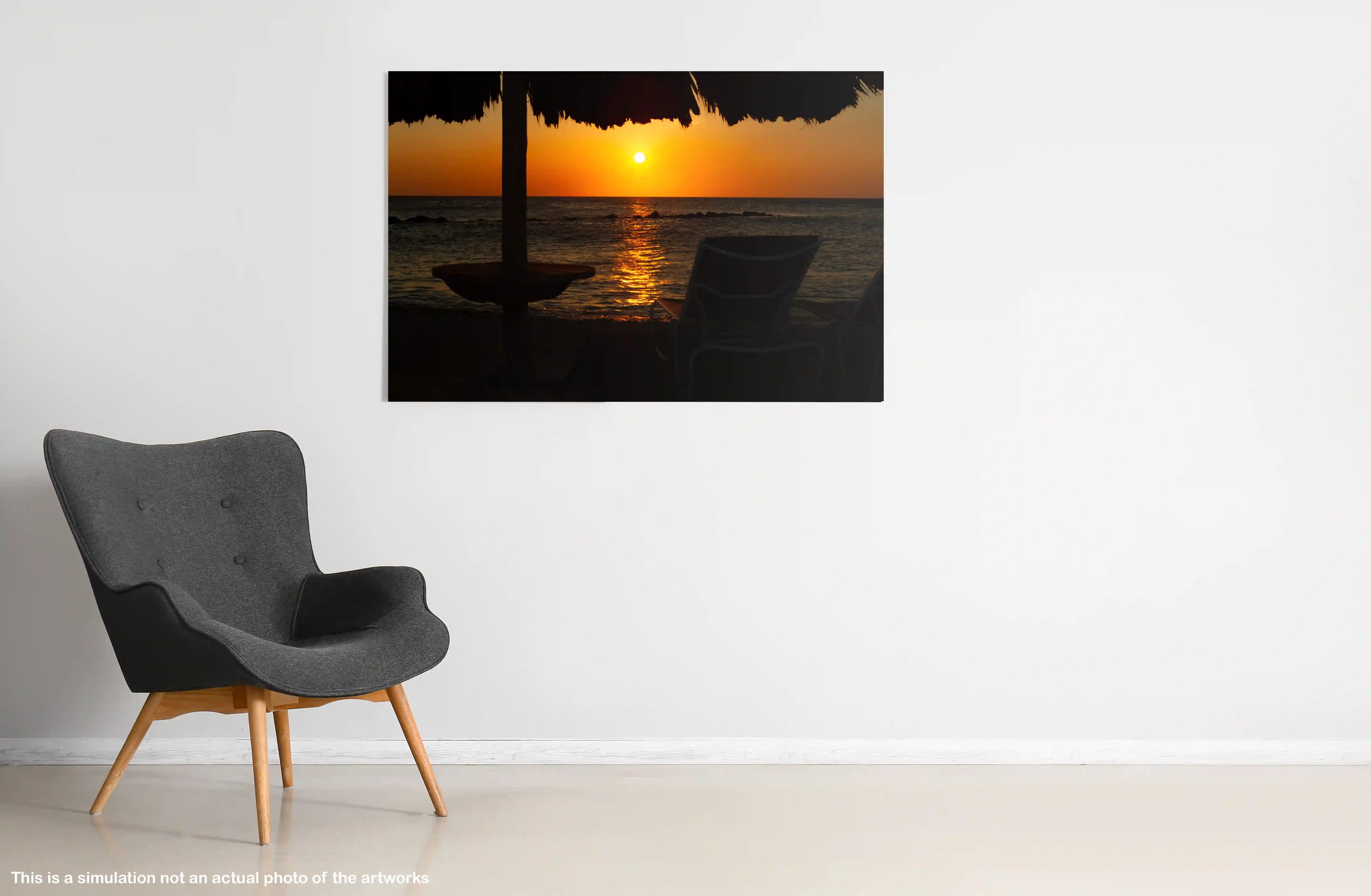 Gray armchair in a room with a large wall-mounted picture of a sunset over water.