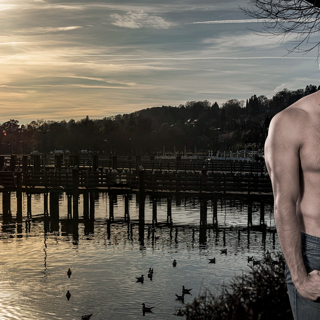 Thumbnail of the serene beauty of a tranquil lakeside scene bathed in the fading light of dusk, paired with the poised presence of a man standing confidently at the water’s edge.