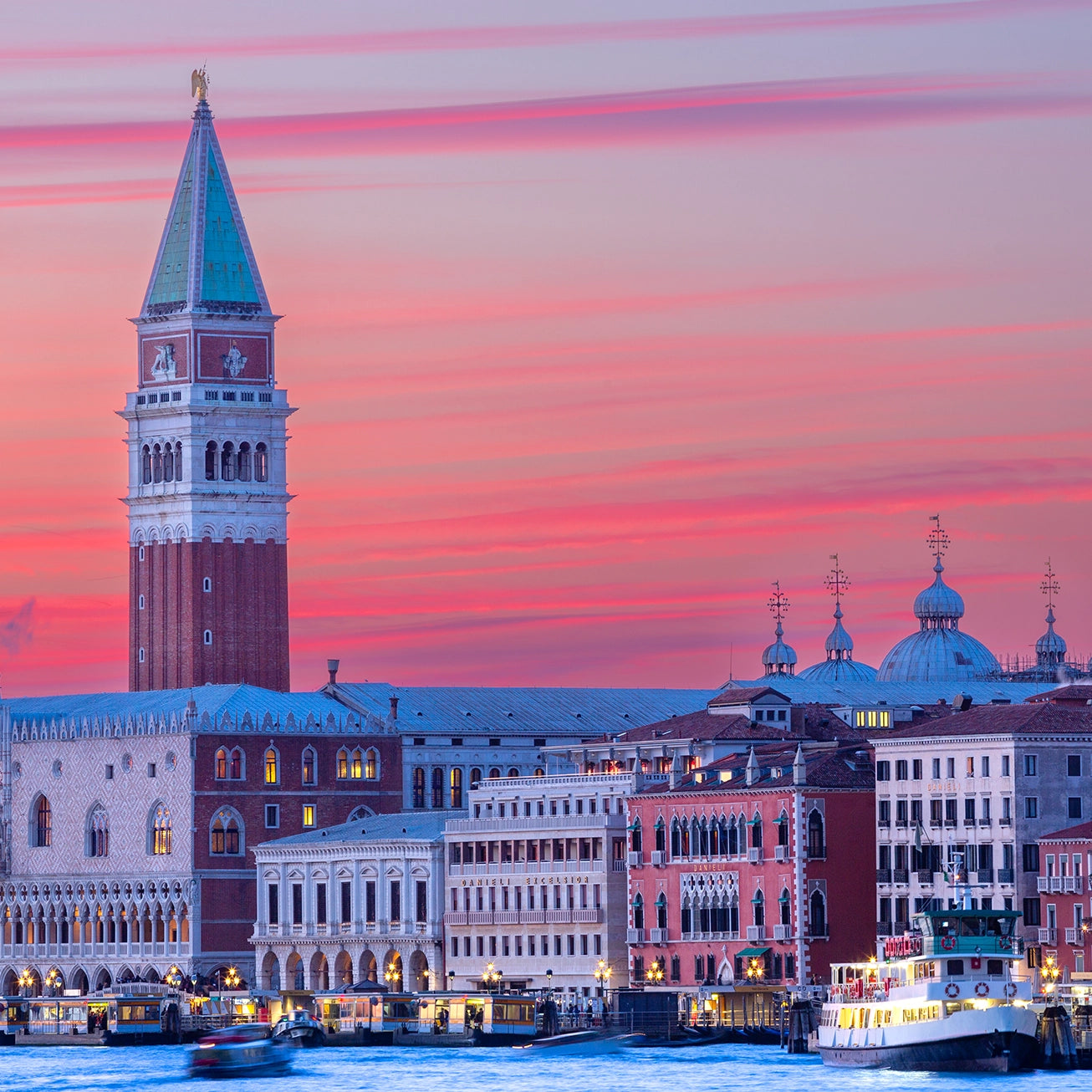 Thumbnail of the enchanting skyline of Venice is bathed in the soft, pastel hues of twilight. The iconic St. Mark's Campanile rises majestically above the historic Doge's Palace, with the ethereal beauty of the Basilica di San Marco's domes silhouetted against the vibrant sky.