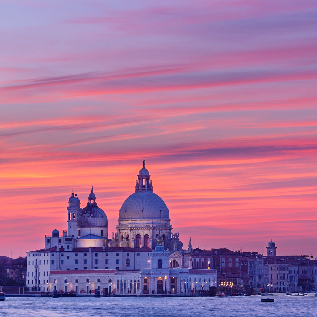 Dome of a large building against a vibrant pink and purple sunset sky.